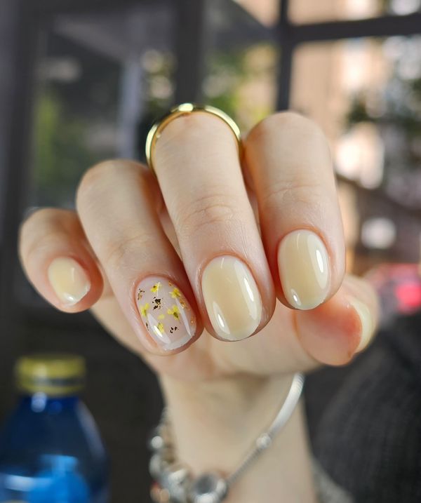 Manicura rusa con nivelación en tono nude con flores secas y pan de oro